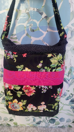 Floral patterned bag with black, pink, and multicolor design on a floral background