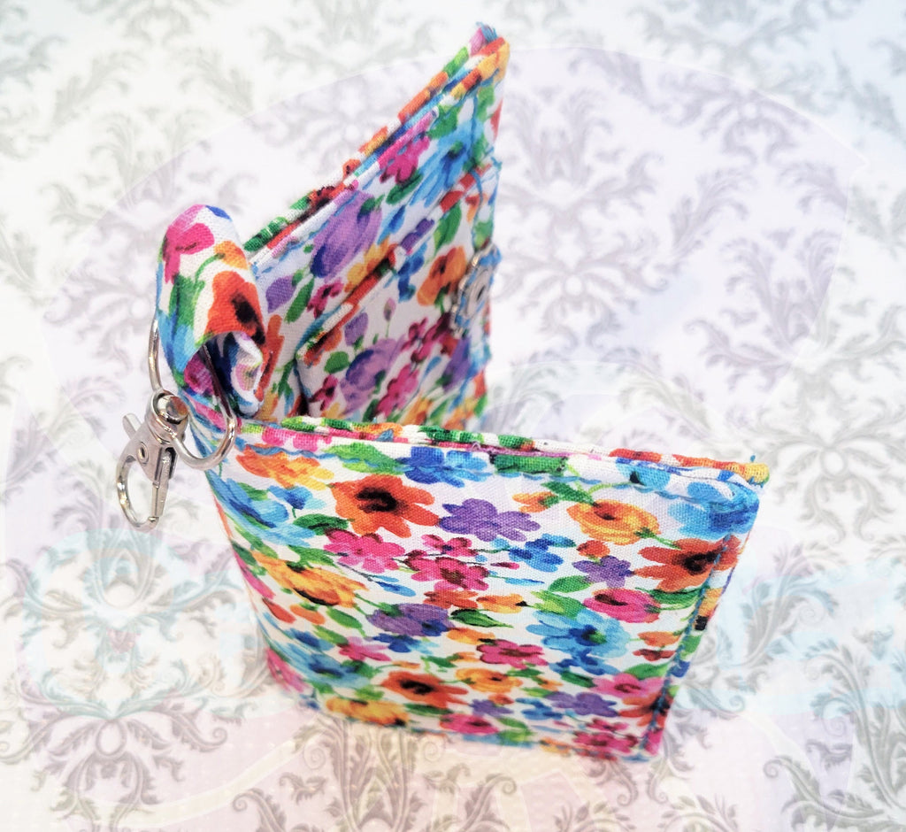Colorful floral-patterned wallet on a textured white background. 