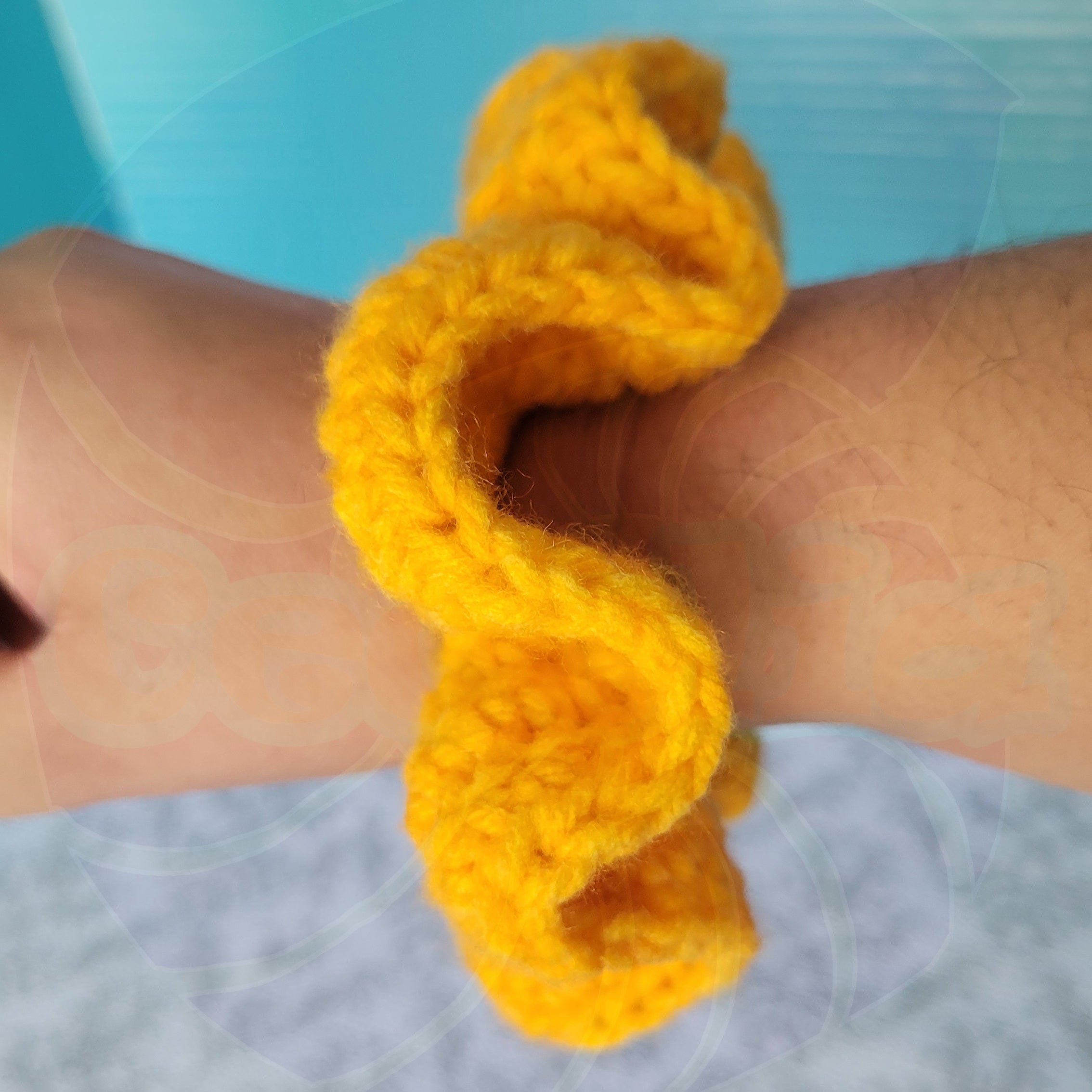Yellow scrunchie on a wrist with a blurred background