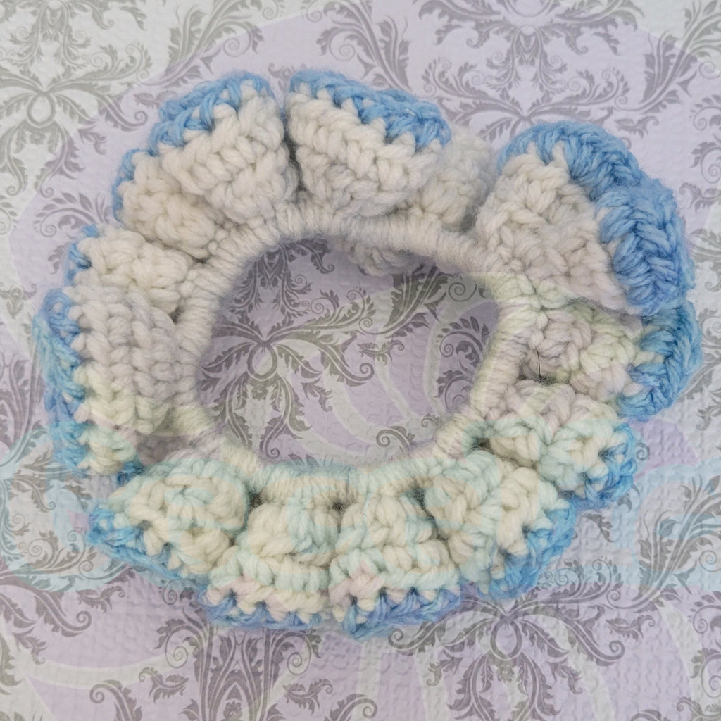 Crocheted scrunchie with blue and beige pattern on a textured background