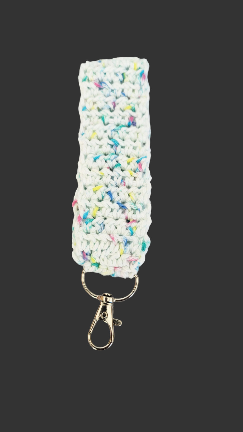 Keychain in white with colorful sparkles on a decorative gray background