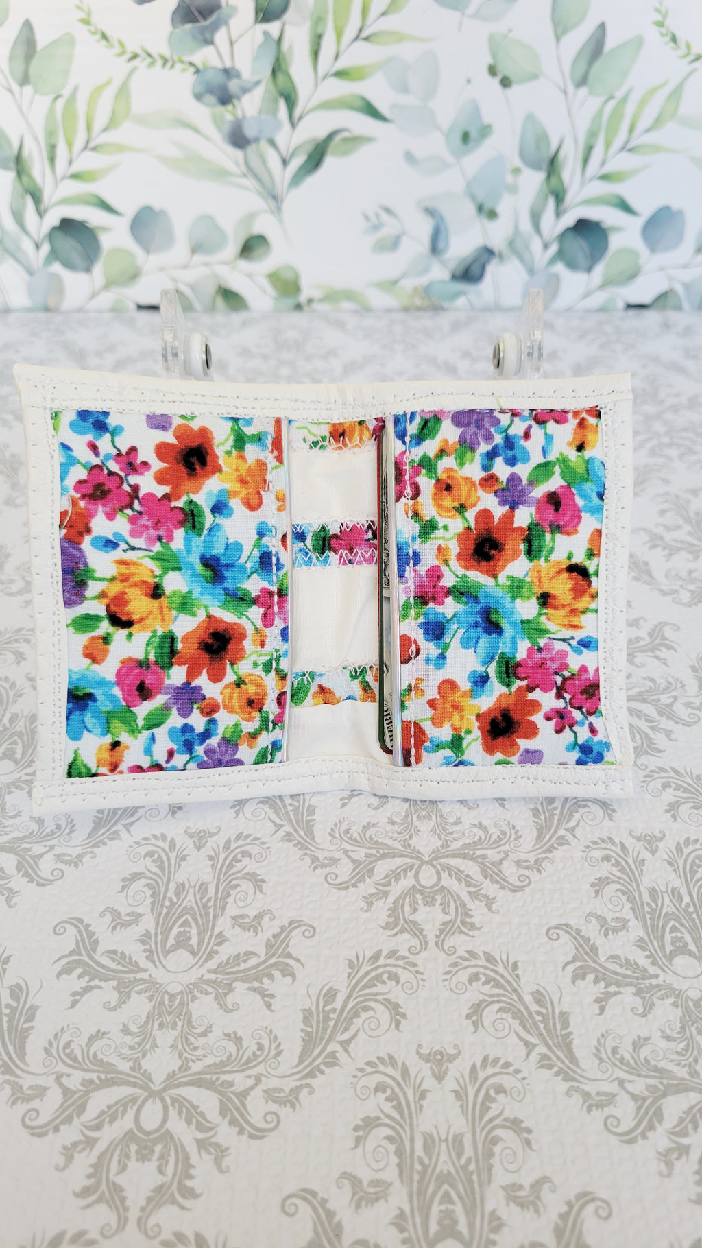 Floral-patterned wallet on a decorative background