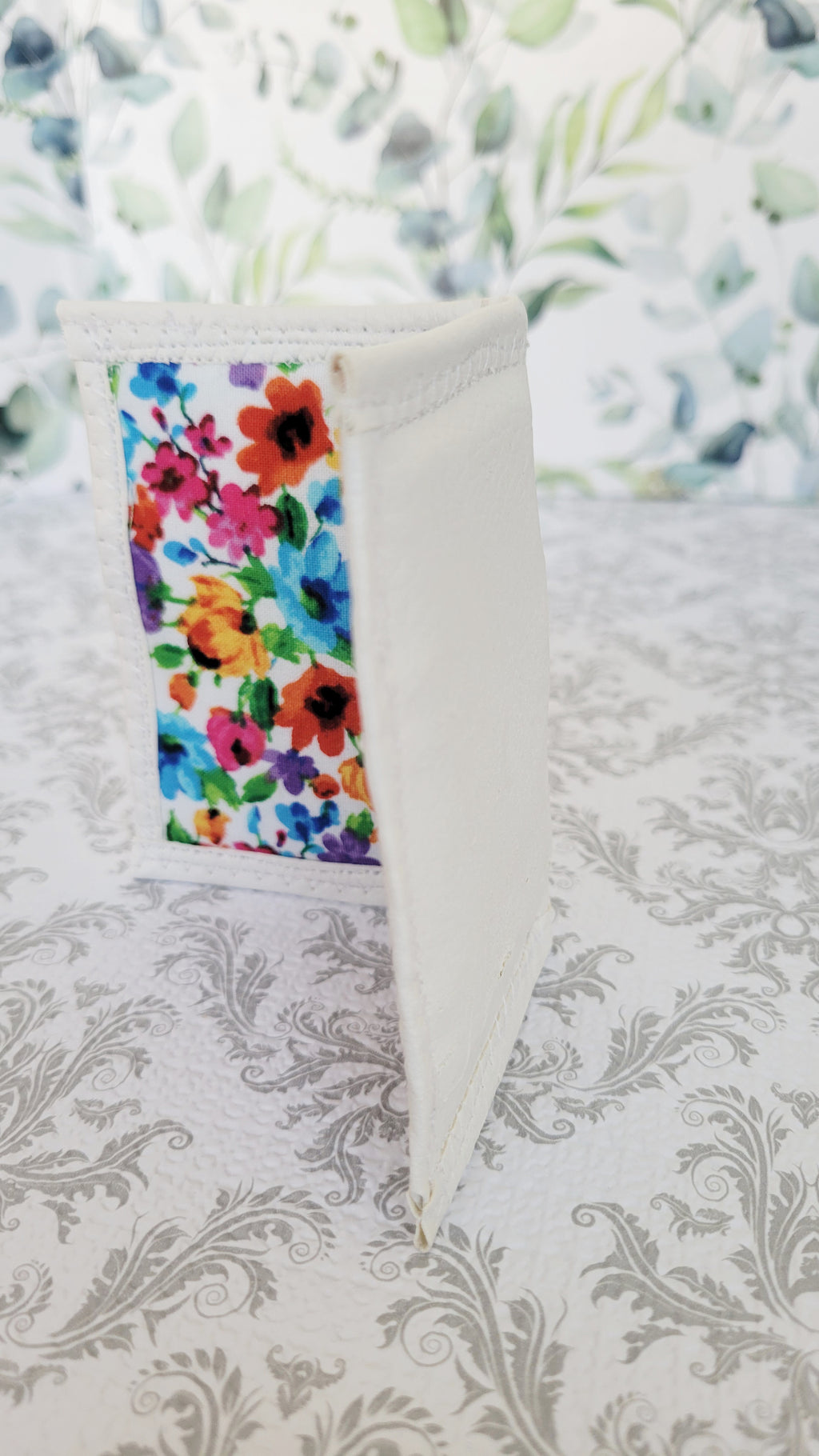 Colorful floral-patterned wallet on a textured white background