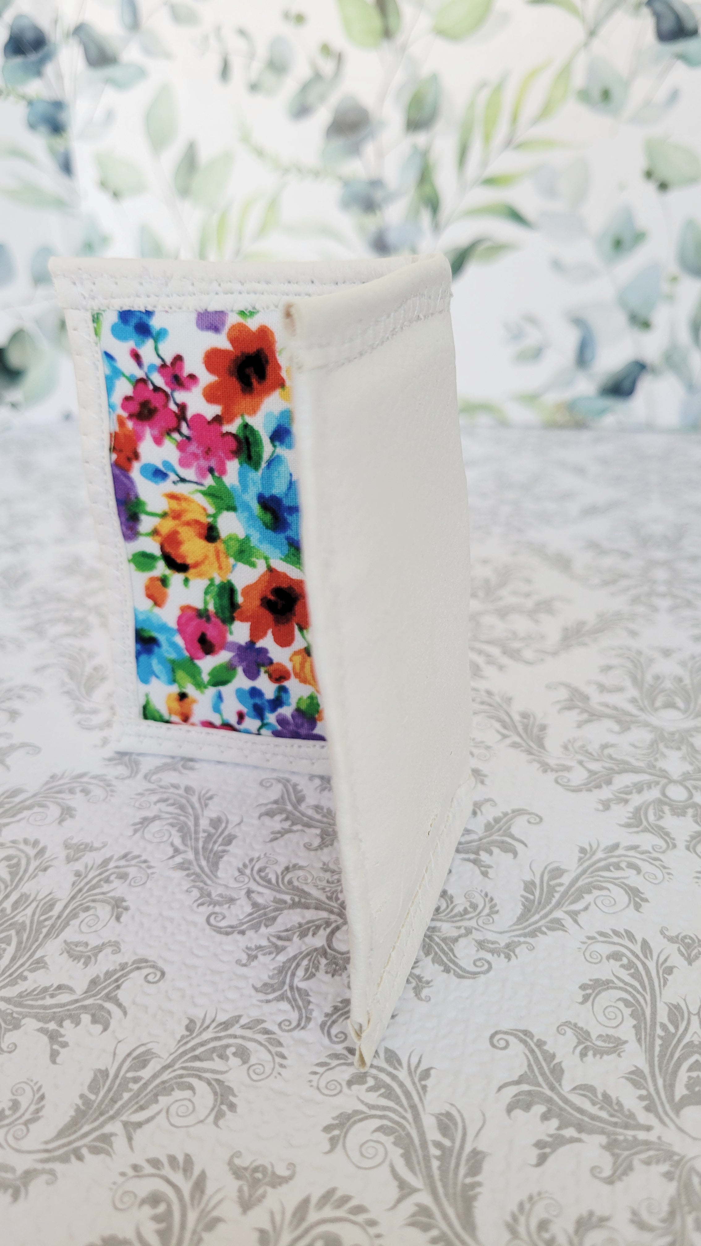 Colorful floral-patterned wallet on a textured white background