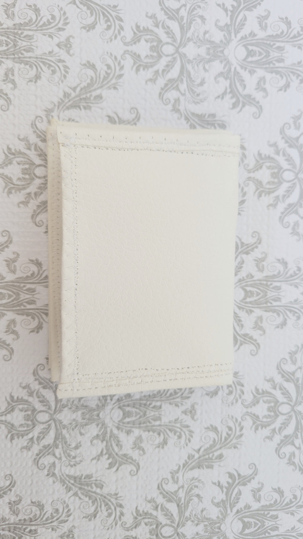 White wallet on a textured gray background