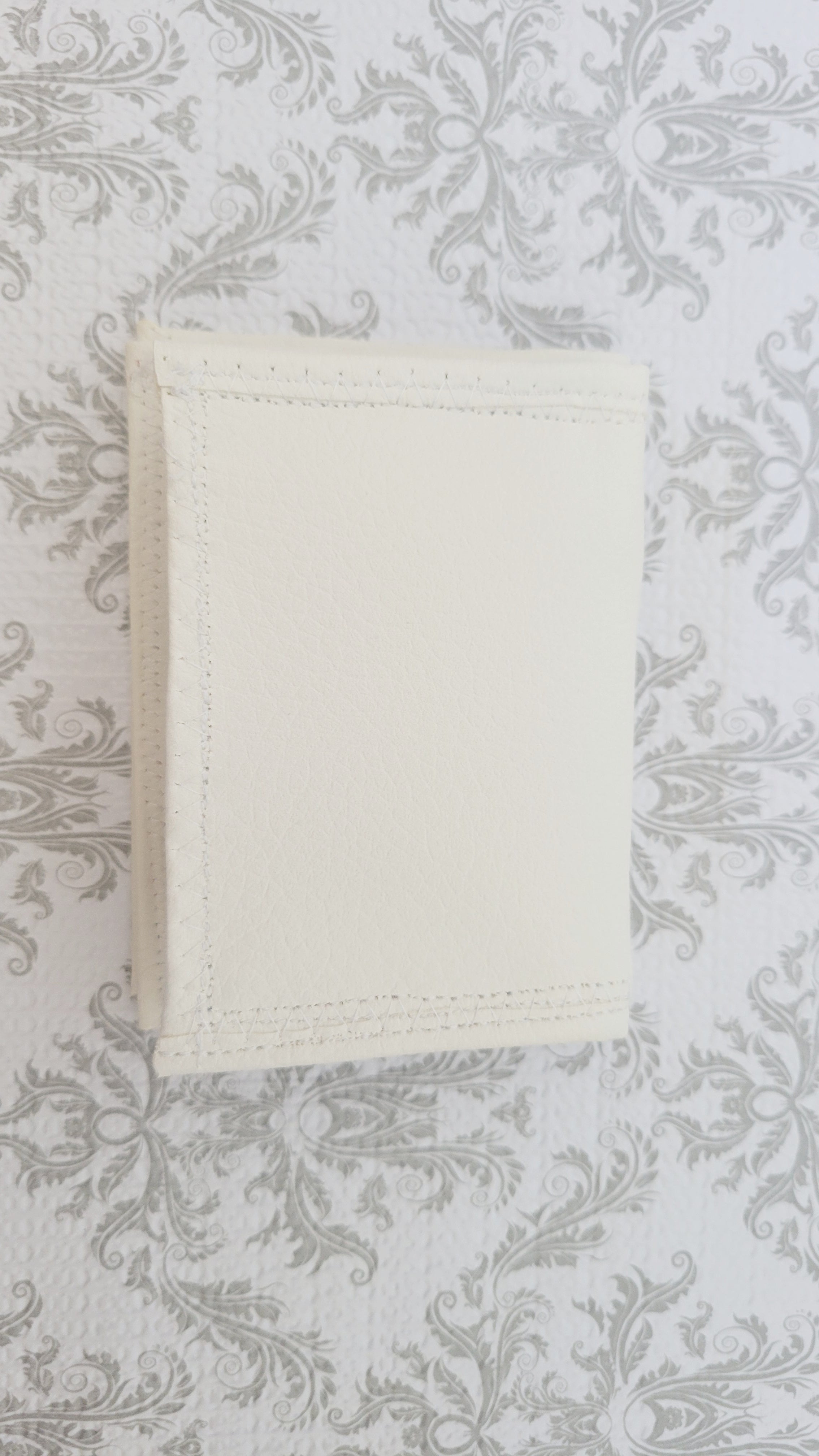 White wallet on a textured gray background