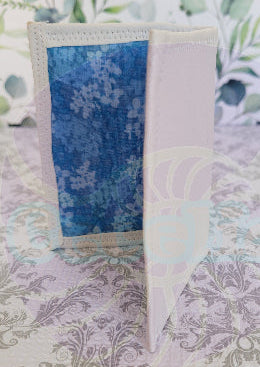 Quilted fabric wallet with blue floral pattern and black fabric with american flag design on a floral background. There are two pocket is floral blue color.