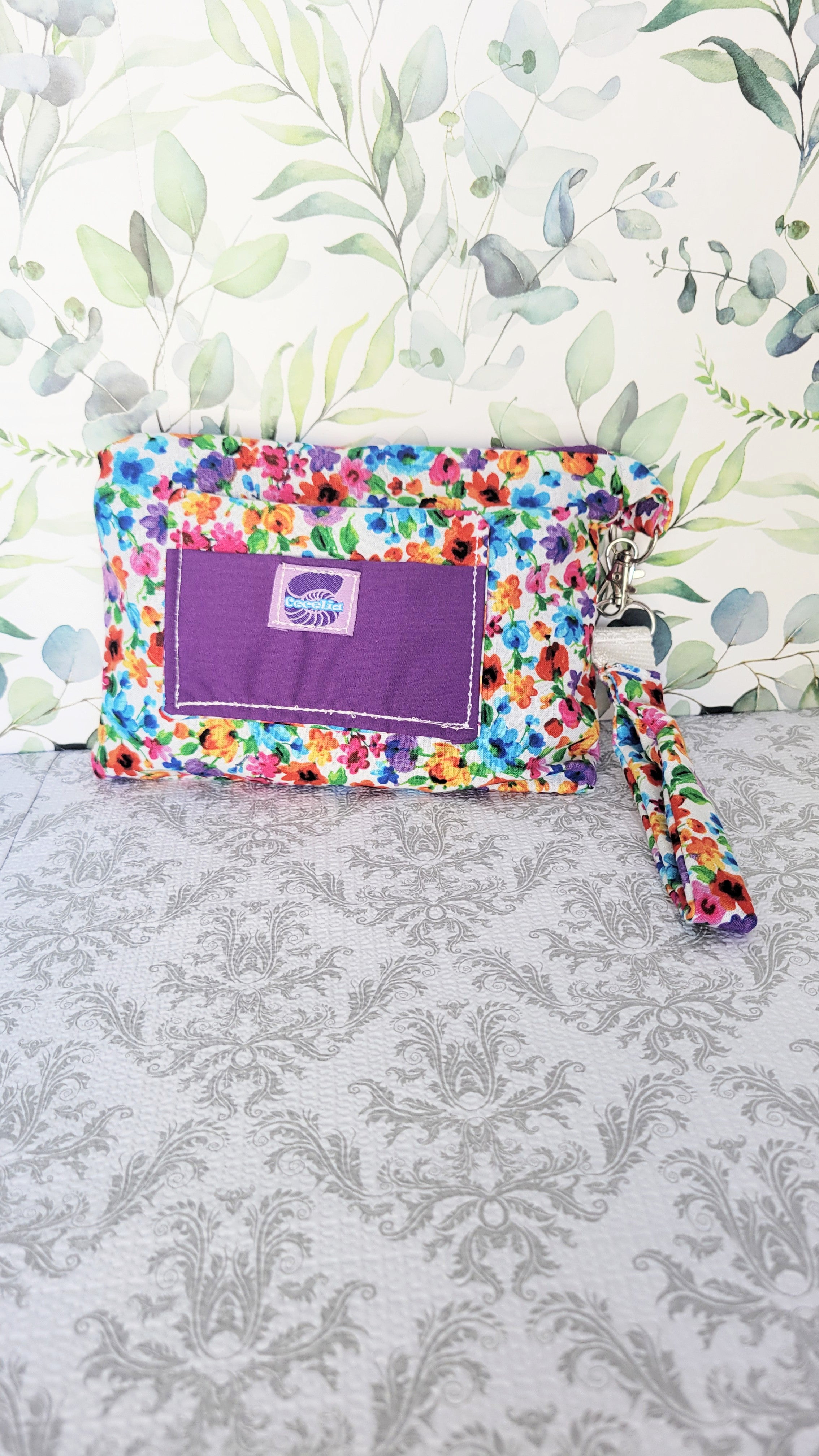colorful Floral-patterned pouch purse in white with a purple pocket on a textured white background