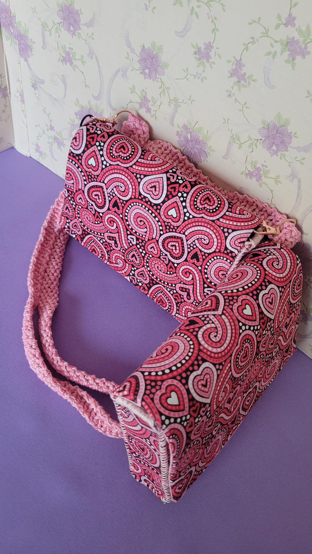 Two Pink Flores Clutch Purse with a ripple effect of hearts in a selection of colors pink, white, red and black. They are placed together to make a V shape,