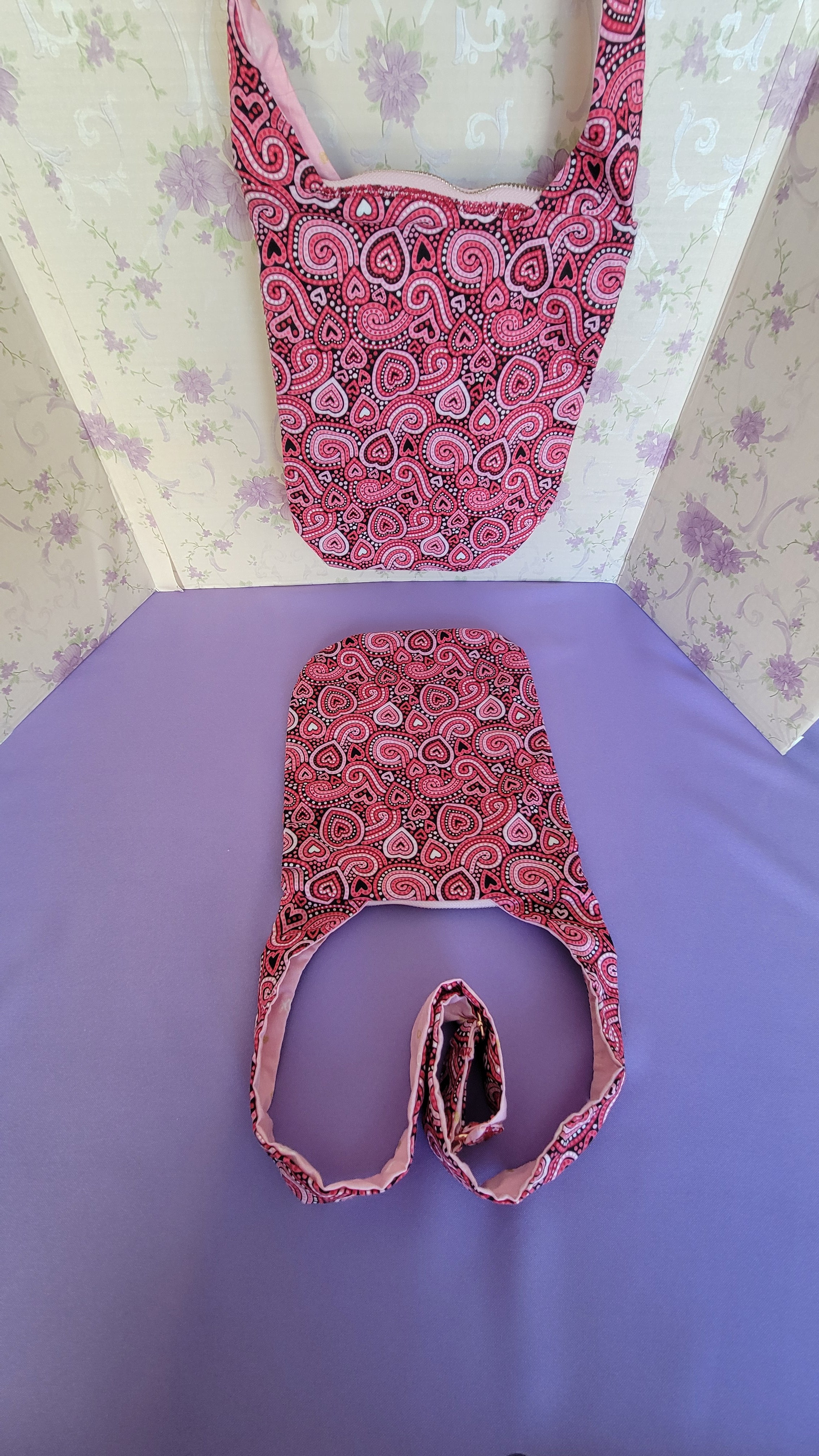 Two Pink crossbody Angelica purses with a ripple effect of hearts in a selection of colors pink, white, red and black.