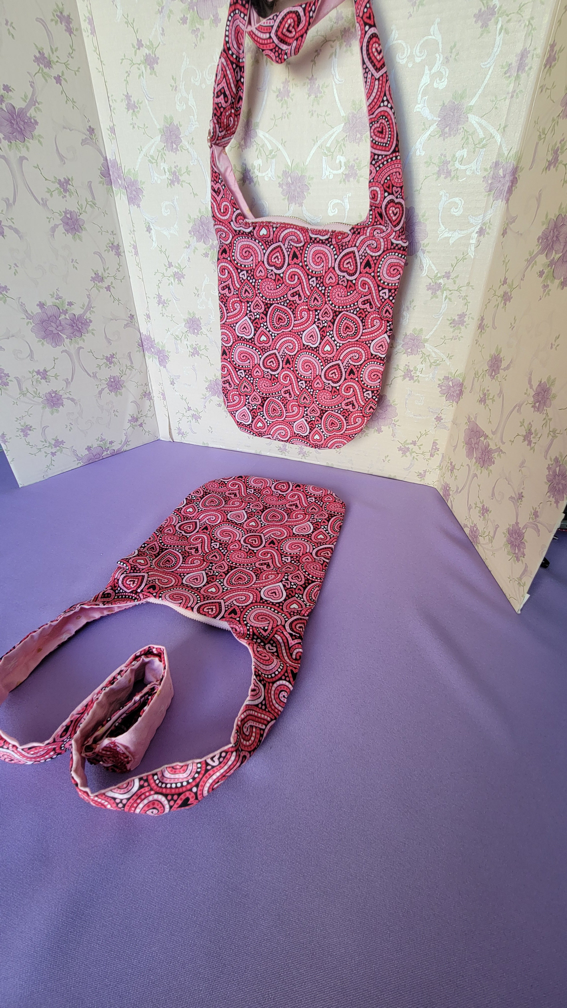 Two pink Angelica purse from the right side angle with a ripple effect of hearts in a selection of colors pink, white, red and black.