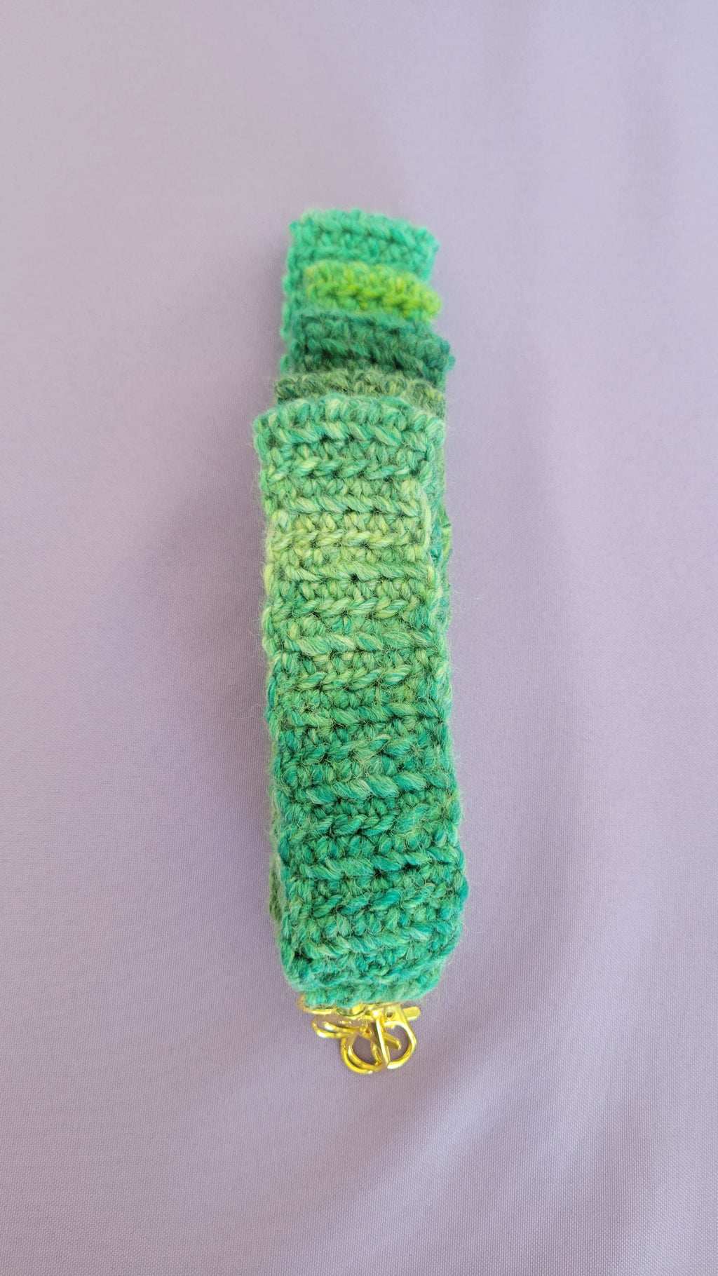 Several green crochet key bracelets items. Stack up together from sizes 5 to 9 inches. All in multiple shades of green.